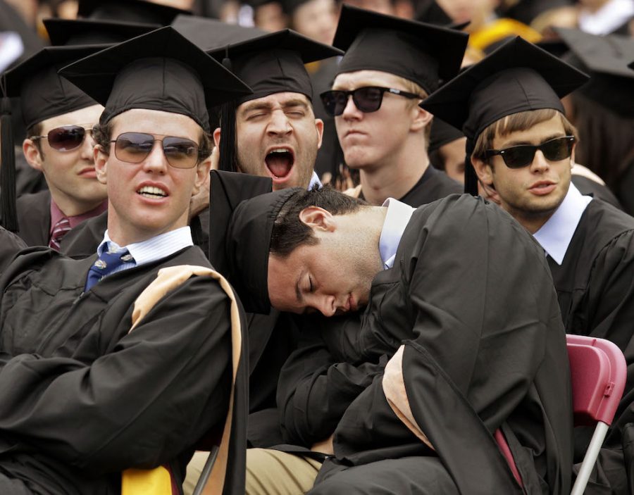 John Fiorenzo, center, catches a brief nap during the address to the graduates at his Boston College Commencement ceremony on the universitys campus in Boston, Monday, May 21, 2012.  (AP Photo/Stephan Savoia)